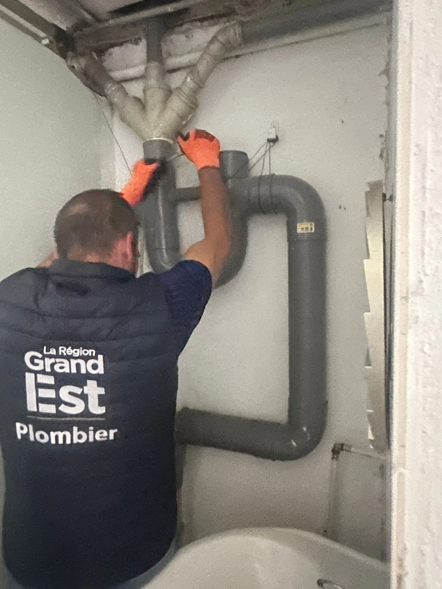 Plombier intervenant sur tuyauterie verticale